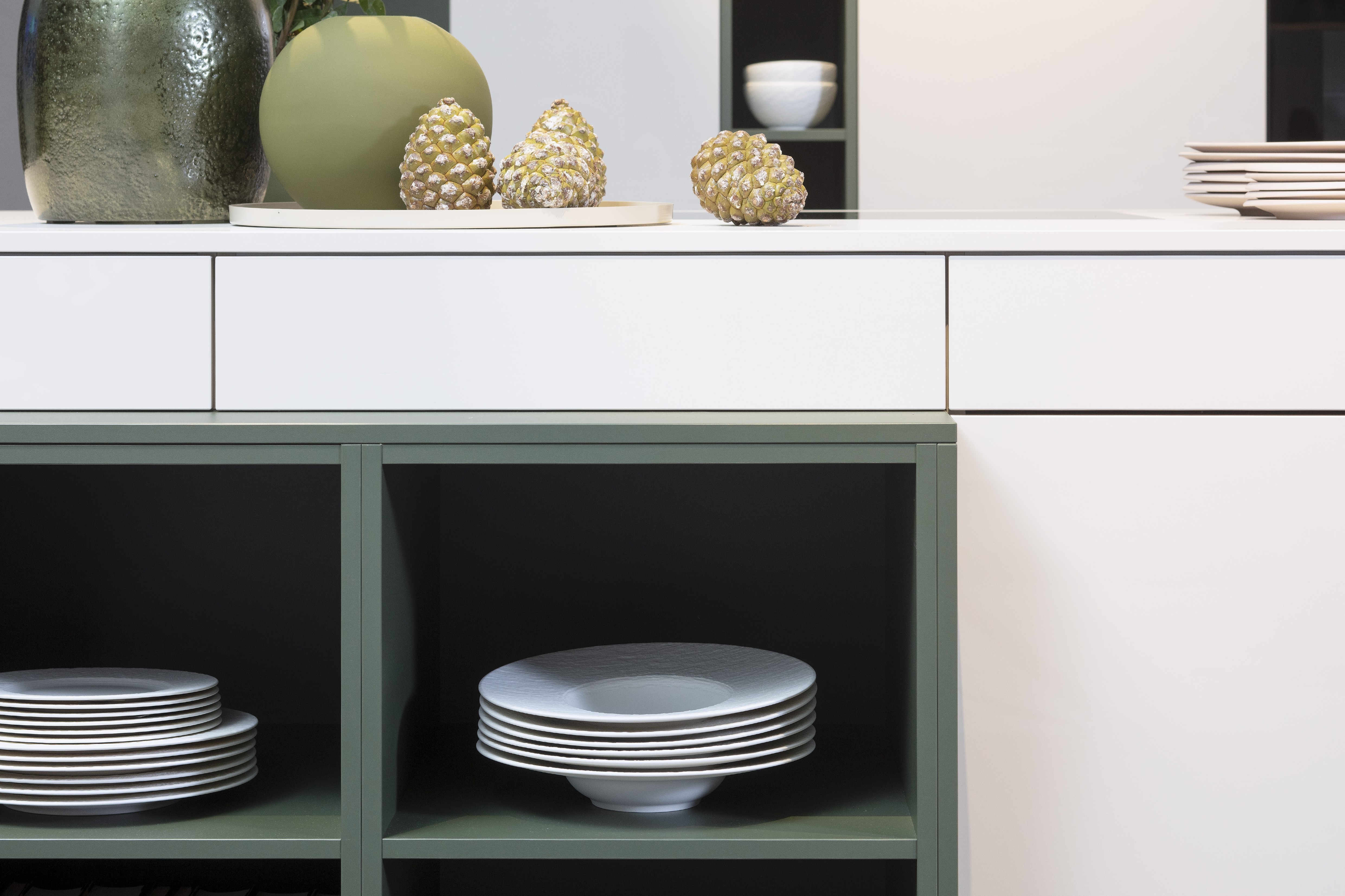 Concept130 Front: Perfect Sense Perfect Brillant Crema magnolia UV Hochglanz lackiert Front 2: Perfect Sense Scala Olivgrün Grüne Front? APL: Perfect Sense Crema Magnolia 16 mm Griff: Schwarz Metall matt Geräte: Blaupunkt Spüle und Armatur: Franke  Features: offene Regale in zweiter Frontfarbe abgesetzt, Apothekerschrank, Spüle in Schwarz.